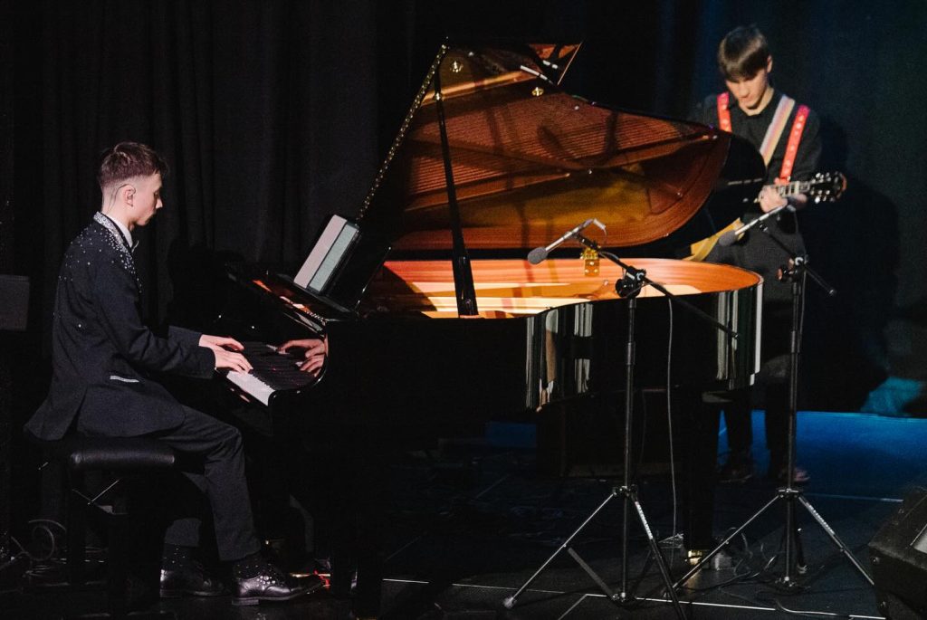 Młodzi muzycy szkoły IN ALTUM grający na instrumentach podczas świątecznego koncertu w MDK Witosa.