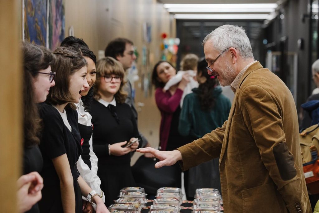 Wolontariusze IN ALTUM przy stoisku z ciastami podczas akcji charytatywnej na rzecz szkoły