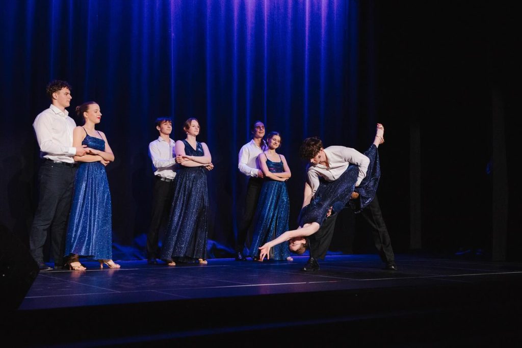 Występ uczniów IN ALTUM – klasyczny układ taneczny w strojach widowiskowych podczas koncertu świątecznego.