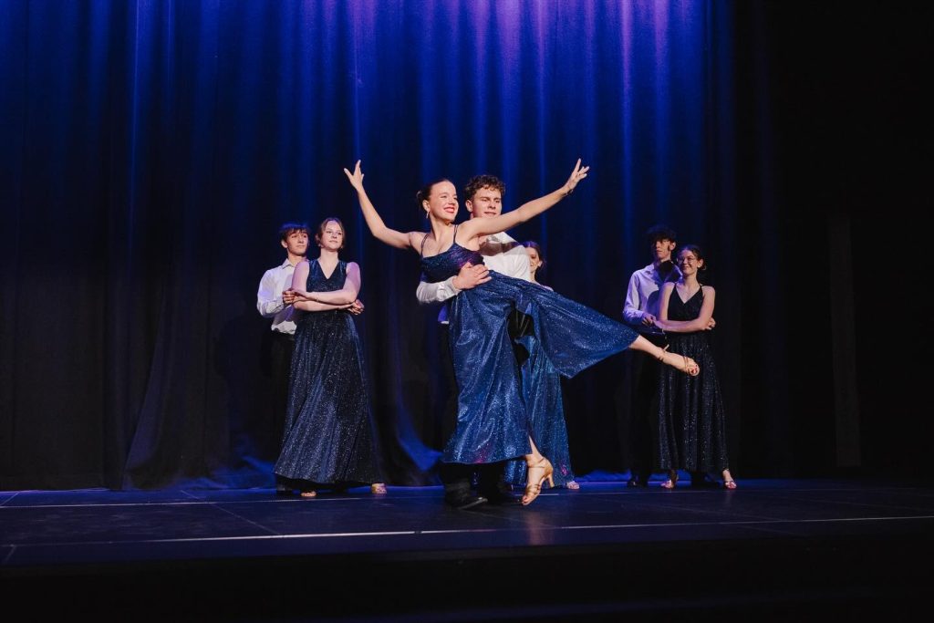 Występ uczniów IN ALTUM – klasyczny układ taneczny w strojach widowiskowych podczas koncertu świątecznego.